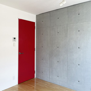 スポット照明と赤のドアが印象的な居室